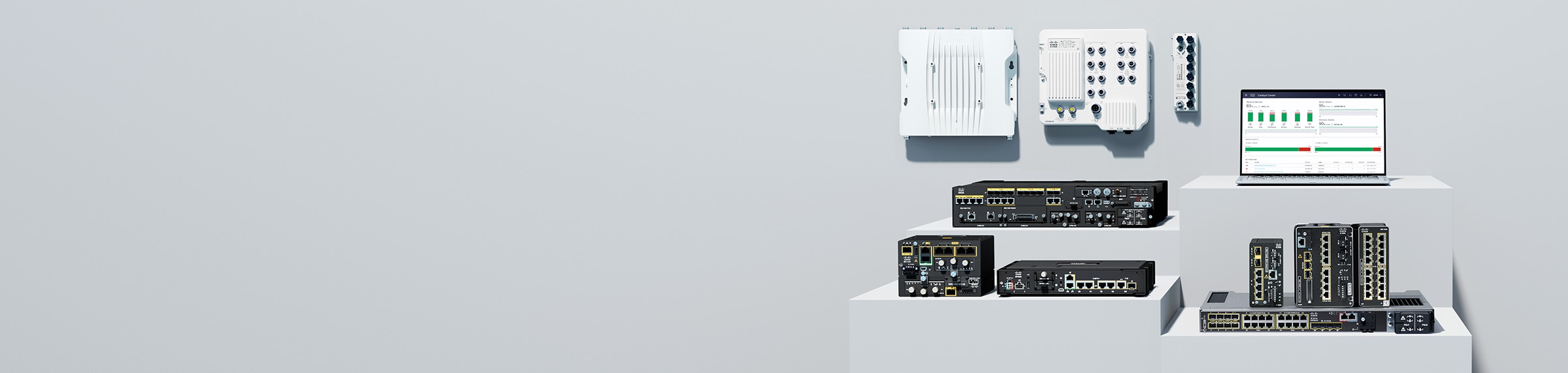 Cisco Industrial IoT routers, switches, access point, and a laptop displaying Cisco Catalyst Center