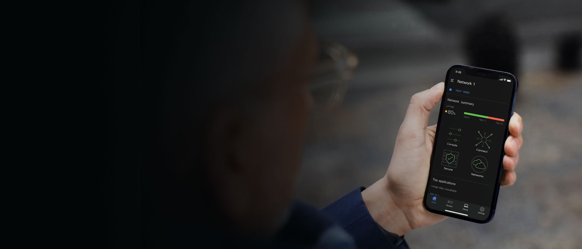 Hand holding a smartphone showing a network summary on the screen