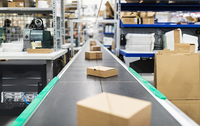 Packages travel down a conveyer belt at a distribution facility